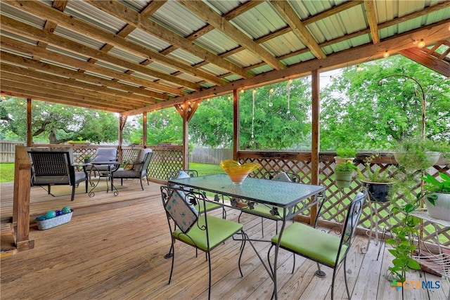 wooden deck with outdoor dining space and a fenced backyard
