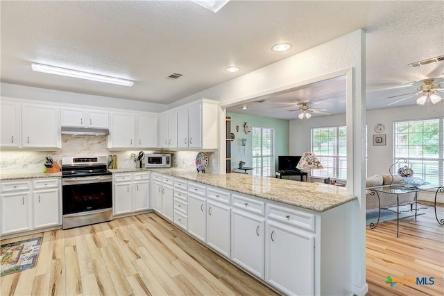 kitchen with light wood-type flooring, a peninsula, appliances with stainless steel finishes, and under cabinet range hood