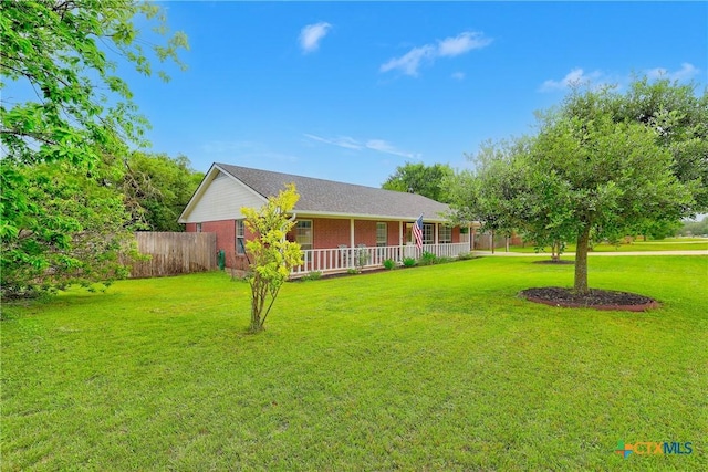 view of front of home with a porch, a front lawn, fence, and brick siding