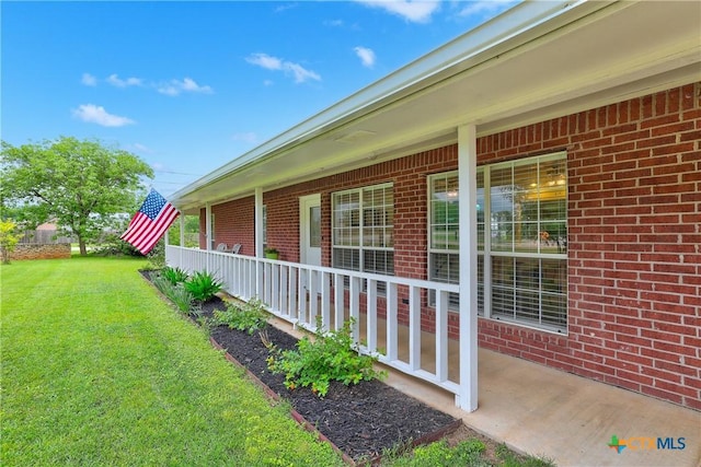 view of home's exterior with a lawn, covered porch, and brick siding
