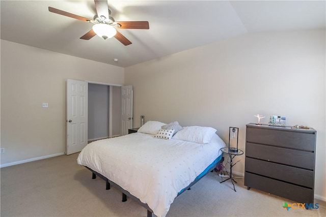 bedroom featuring a ceiling fan, lofted ceiling, light colored carpet, and baseboards