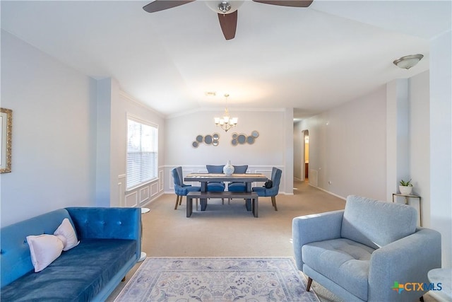 living area featuring light colored carpet, ceiling fan with notable chandelier, crown molding, and lofted ceiling