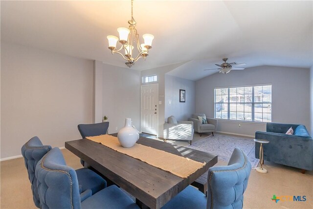 dining room featuring baseboards, lofted ceiling, light colored carpet, and ceiling fan with notable chandelier