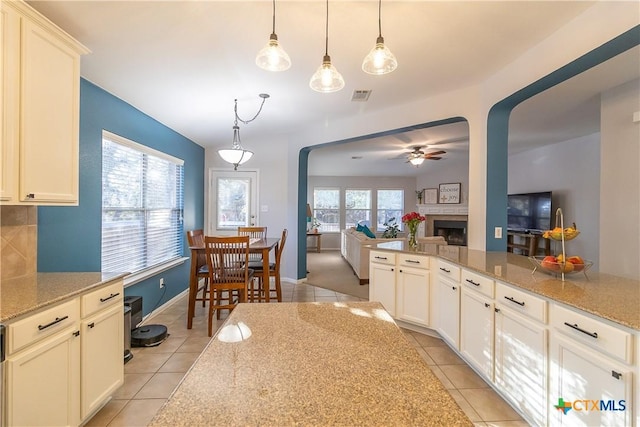 kitchen featuring arched walkways, visible vents, a wealth of natural light, and a ceiling fan