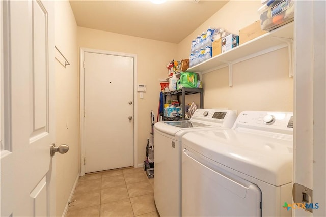 laundry room with washer and clothes dryer, laundry area, and light tile patterned floors