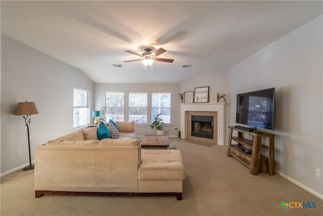 living room featuring visible vents, a tiled fireplace, vaulted ceiling, light carpet, and a ceiling fan