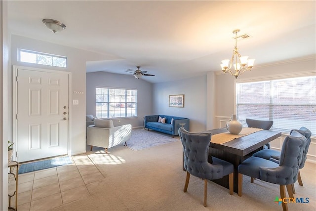 dining space with visible vents, lofted ceiling, light colored carpet, and ceiling fan with notable chandelier