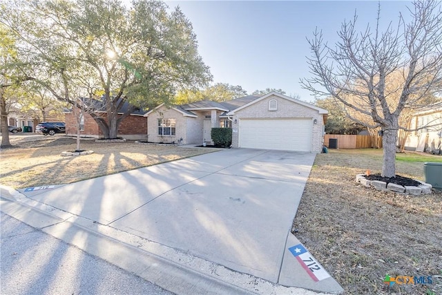 ranch-style home with concrete driveway, an attached garage, fence, and brick siding