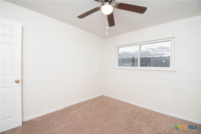 empty room with a ceiling fan, baseboards, carpet floors, and a textured ceiling