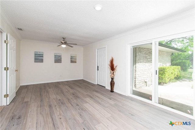 empty room with baseboards, visible vents, light wood-style floors, a ceiling fan, and crown molding
