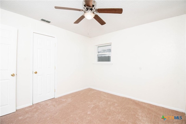 unfurnished bedroom featuring light colored carpet, baseboards, and visible vents
