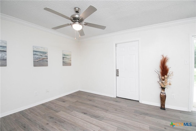 spare room with a ceiling fan, wood finished floors, a textured ceiling, and crown molding