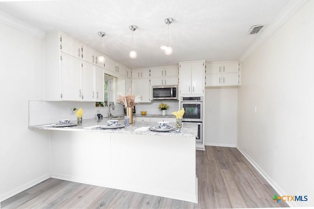 kitchen with stainless steel appliances, light wood-type flooring, baseboards, a peninsula, and white cabinetry