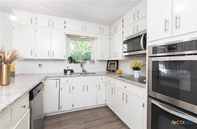 kitchen with stainless steel appliances, backsplash, and white cabinetry