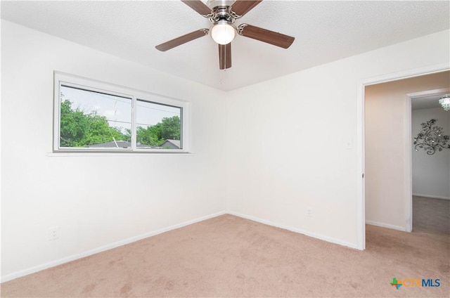 spare room featuring baseboards, light colored carpet, and ceiling fan