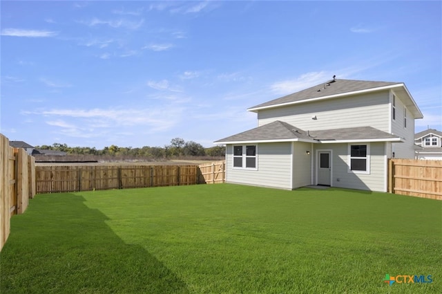 rear view of property with a lawn