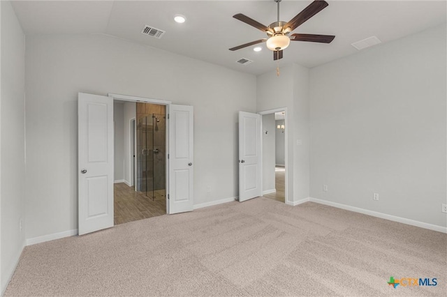 unfurnished bedroom featuring ceiling fan, light carpet, and vaulted ceiling