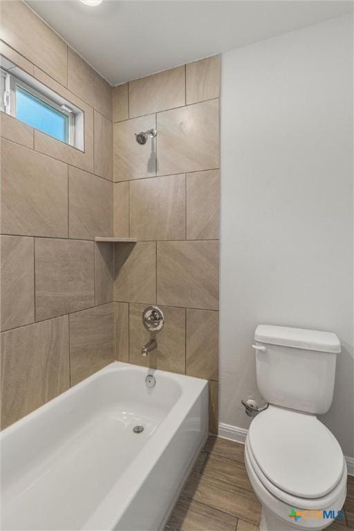 bathroom featuring toilet and tiled shower / bath combo