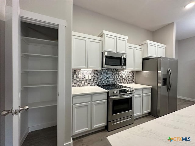 kitchen featuring tasteful backsplash, stainless steel appliances, dark hardwood / wood-style floors, and white cabinets