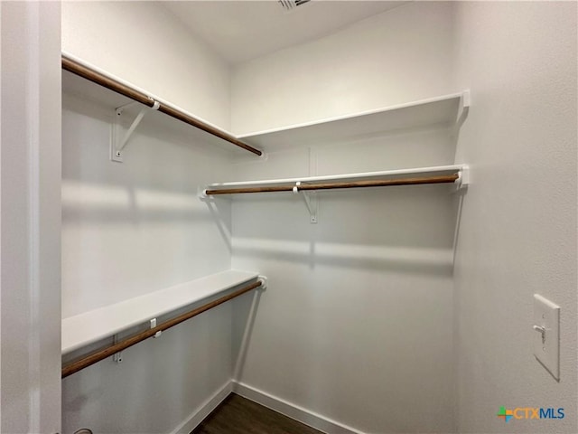 walk in closet featuring dark wood-type flooring