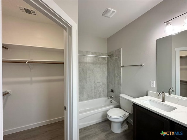 full bathroom with hardwood / wood-style flooring, vanity, toilet, and tiled shower / bath combo