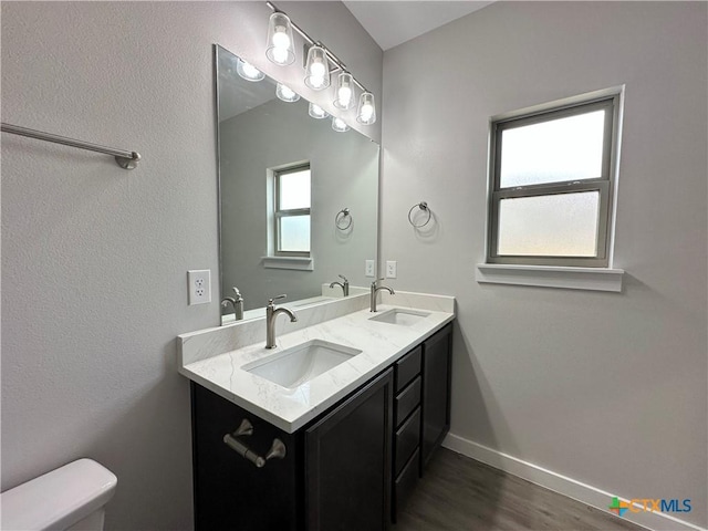 bathroom with hardwood / wood-style flooring, vanity, and toilet