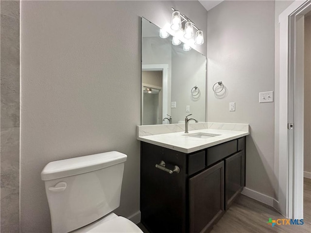 bathroom featuring hardwood / wood-style flooring, vanity, and toilet