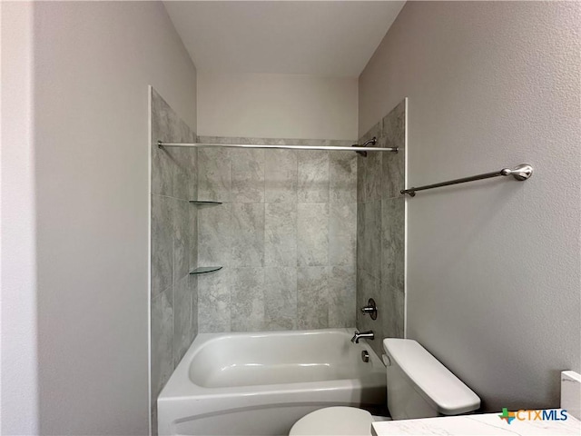 full bathroom featuring tiled shower / bath, vanity, and toilet