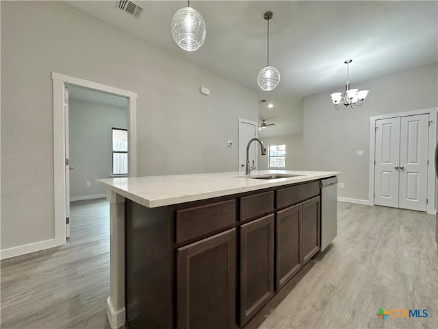 kitchen featuring a kitchen island with sink, sink, decorative light fixtures, and dishwasher