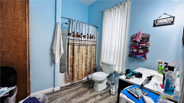 bathroom featuring hardwood / wood-style flooring, shower / bath combination with curtain, and toilet