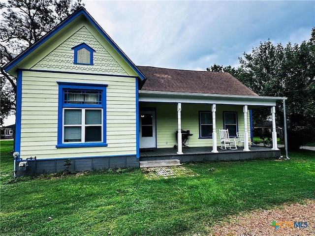 view of front of house with covered porch and a front lawn