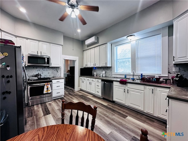 kitchen featuring white cabinets, hardwood / wood-style floors, ceiling fan, and stainless steel appliances