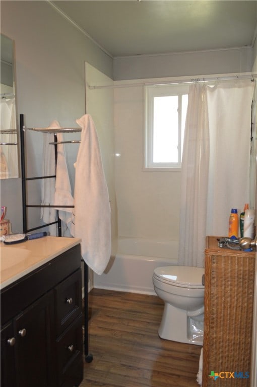 full bathroom featuring hardwood / wood-style flooring, vanity, shower / bathtub combination with curtain, and toilet