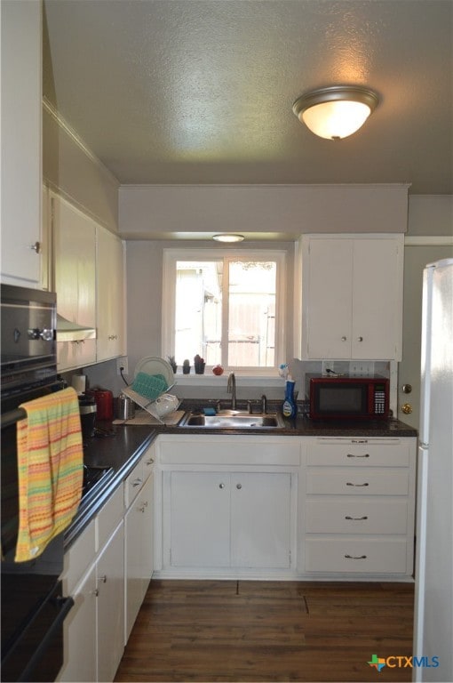 kitchen featuring dark wood-type flooring, white cabinetry, white refrigerator, and sink