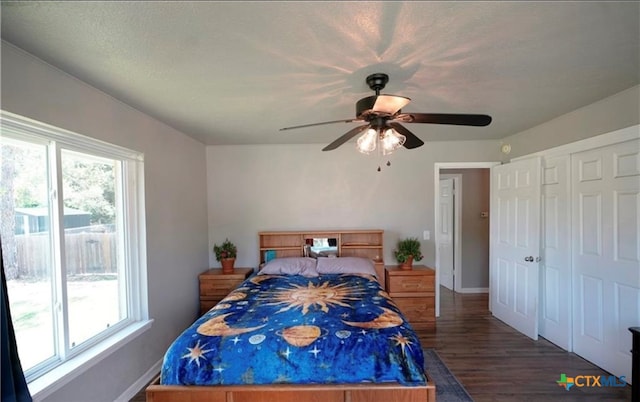 bedroom featuring ceiling fan, dark hardwood / wood-style floors, a closet, and a textured ceiling