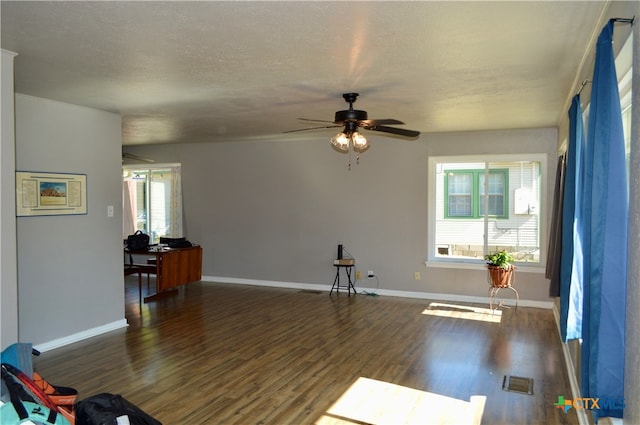 interior space with a textured ceiling, dark hardwood / wood-style floors, and ceiling fan