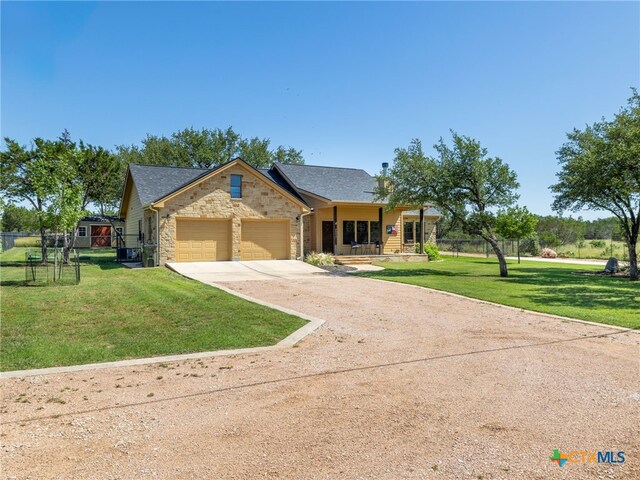2091 County Road 100, Burnet, TX 78611 - view of front facade featuring dirt driveway, a garage, and stone siding