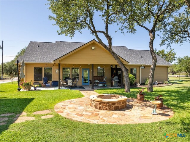 2091 County Road 100, Burnet, TX 78611 - back of house featuring a fire pit, a patio, a shingled roof, and a yard