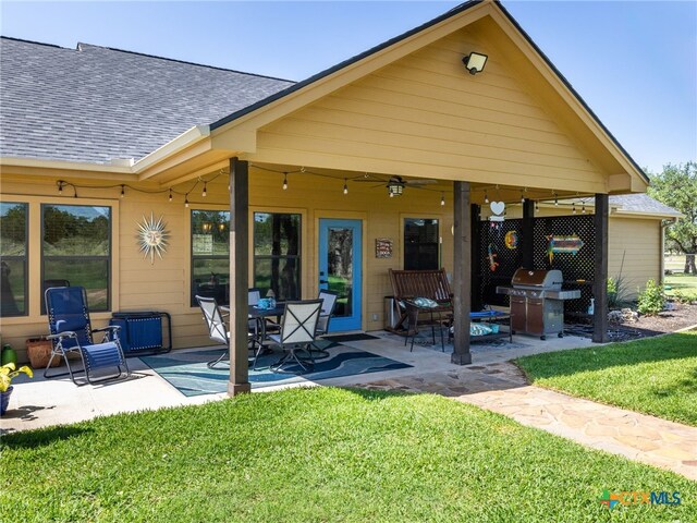 2091 County Road 100, Burnet, TX 78611 - rear view of house featuring roof with shingles, a patio area, a lawn, and ceiling fan