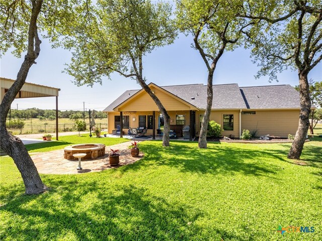 2091 County Road 100, Burnet, TX 78611 - back of property featuring a fire pit, a patio area, and a yard