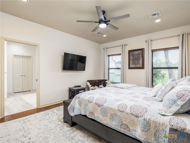 2091 County Road 100, Burnet, TX 78611 - bedroom with multiple windows, wood finished floors, baseboards, a ceiling fan, and recessed lighting