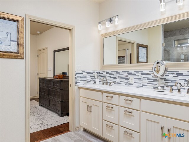 2091 County Road 100, Burnet, TX 78611 - bathroom featuring double vanity, backsplash, wood finished floors, and a stall shower
