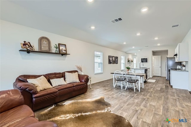 living room featuring sink and light hardwood / wood-style floors