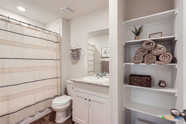 full bathroom with wood-type flooring, vanity, shower / tub combo, and toilet