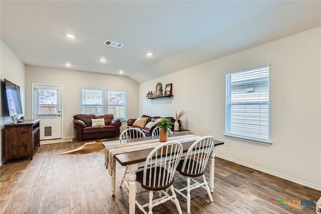 dining space featuring lofted ceiling and hardwood / wood-style flooring