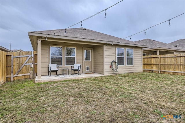 rear view of house with a lawn and a patio