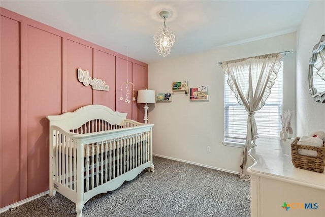 bedroom featuring carpet, a chandelier, and a nursery area