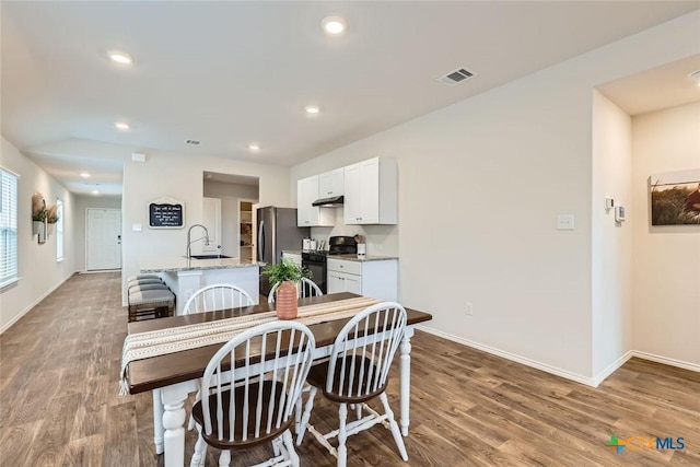 dining area featuring sink and light wood-type flooring