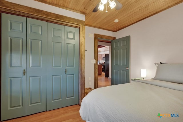 bedroom with black fridge, wooden ceiling, a closet, ceiling fan, and light hardwood / wood-style floors