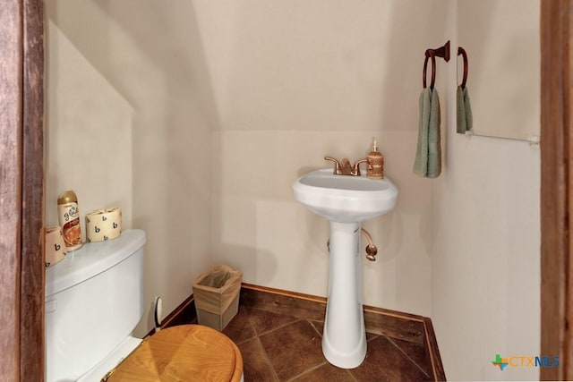 bathroom with lofted ceiling, tile patterned floors, and toilet